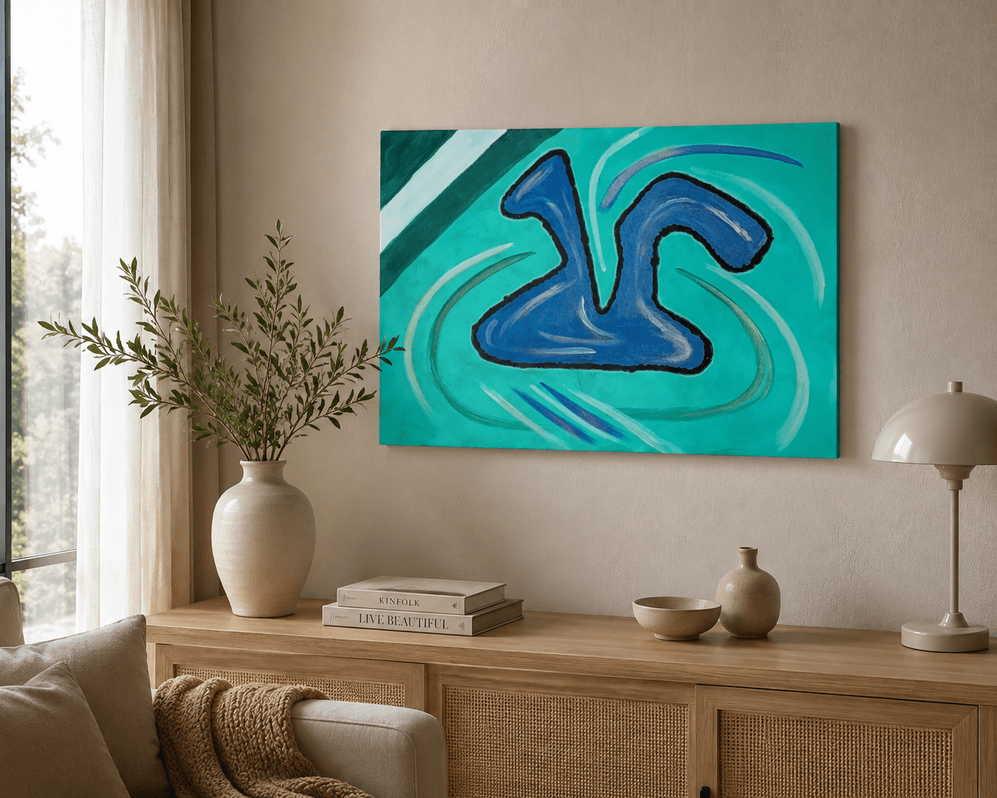 Pintura abstracta azul sobre fondo turquesa en una pared beige sobre un aparador de madera.